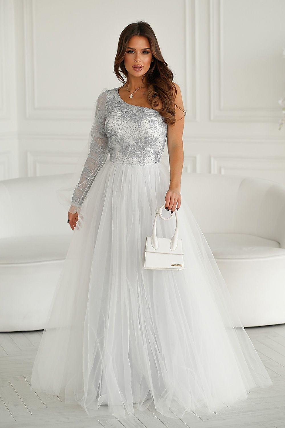 Chic and modern one shoulder prom gown by Bicotone, elegantly styled in silver lace with a voluminous mesh skirt, paired with a fashionable handbag for a complete look.