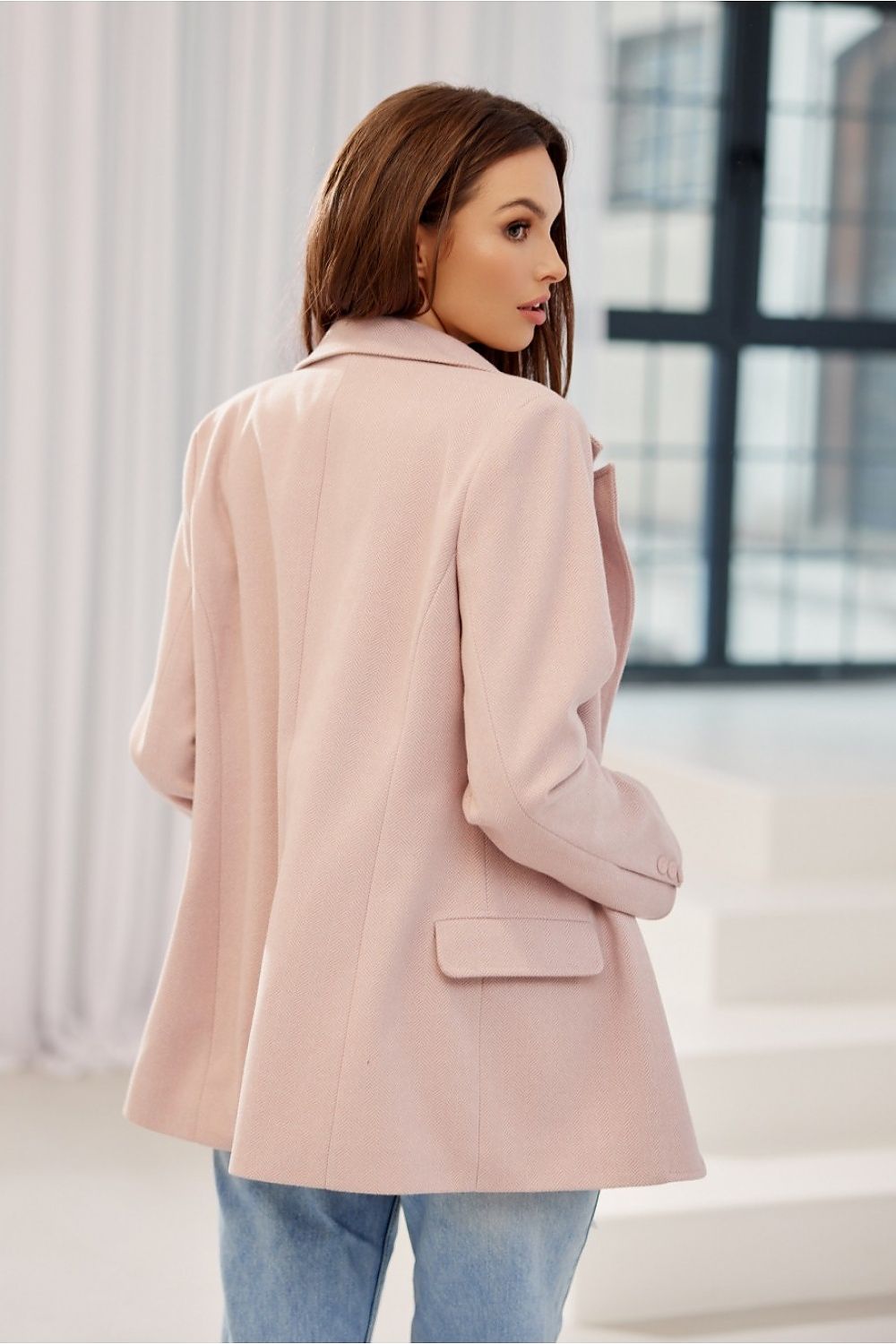Elegant woman showcasing the back view of Freya Classic Blazer Jacket by Roco Fashion in soft pink herringbone fabric, featuring a flowing silhouette and tailored design.