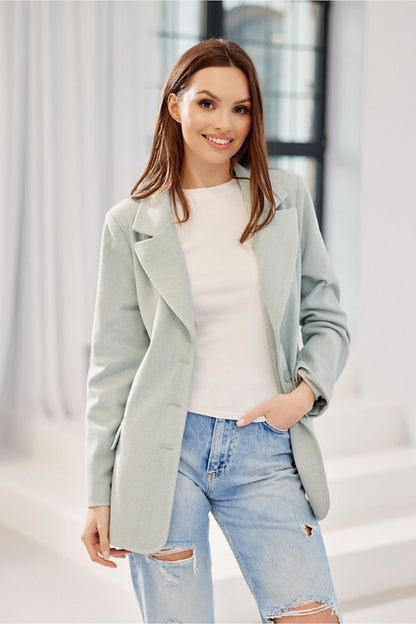 Charming woman wearing the Freya Classic Blazer Jacket by Roco Fashion in a light pastel mint hue, paired with a casual white top, blending sophistication with style.