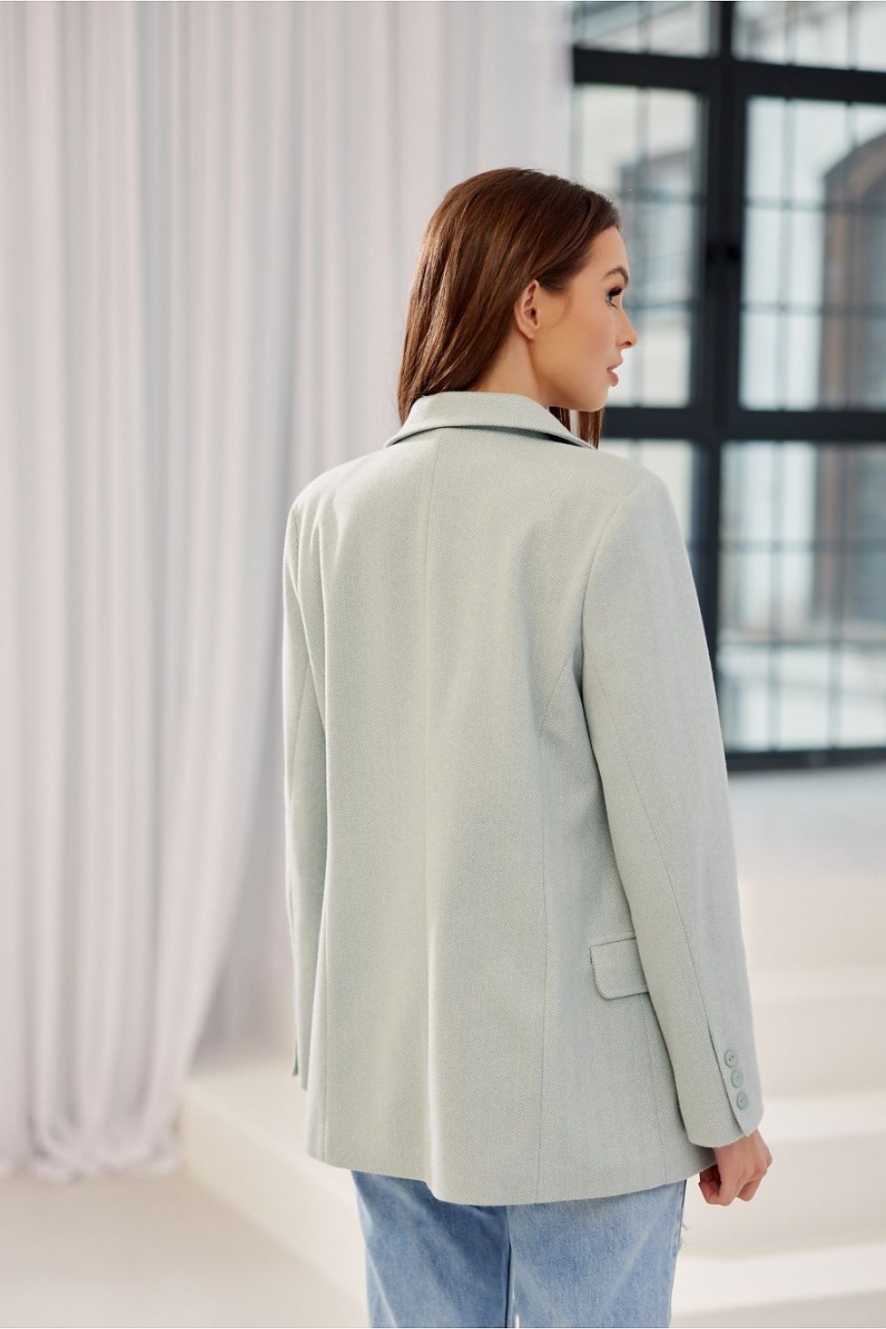 Graceful woman showcasing the back of the Freya Classic Blazer Jacket by Roco Fashion in mint, demonstrating classy tailoring and contemporary luxury.
