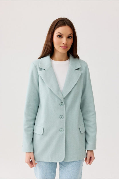 Elegant woman showcasing a light blue Freya Classic Blazer Jacket by Roco Fashion, featuring a sophisticated herringbone design and button closure, perfect for upscale occasions.
