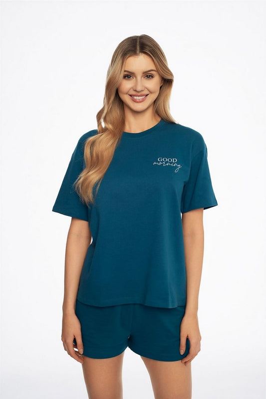 Elegant woman wearing Henderson women's Sea Abstract cotton pyjamas in soft terry. The loose-fit design features a short-sleeved top with a subtle "GOOD morning" print, offering year-round comfort.