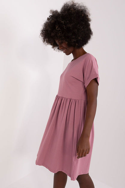 Side profile of a stylish flared cotton dress in pink by Rue Paris, showcasing the dress's flattering fit and easy elegance, ideal for relaxed outings.
