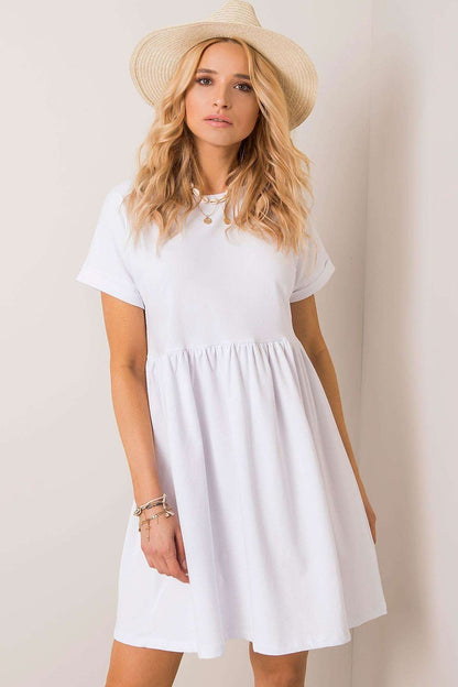 Fashion-forward Rue Paris white flared cotton dress with short sleeves and flowing design, paired with a stylish straw hat for an effortless chic look.