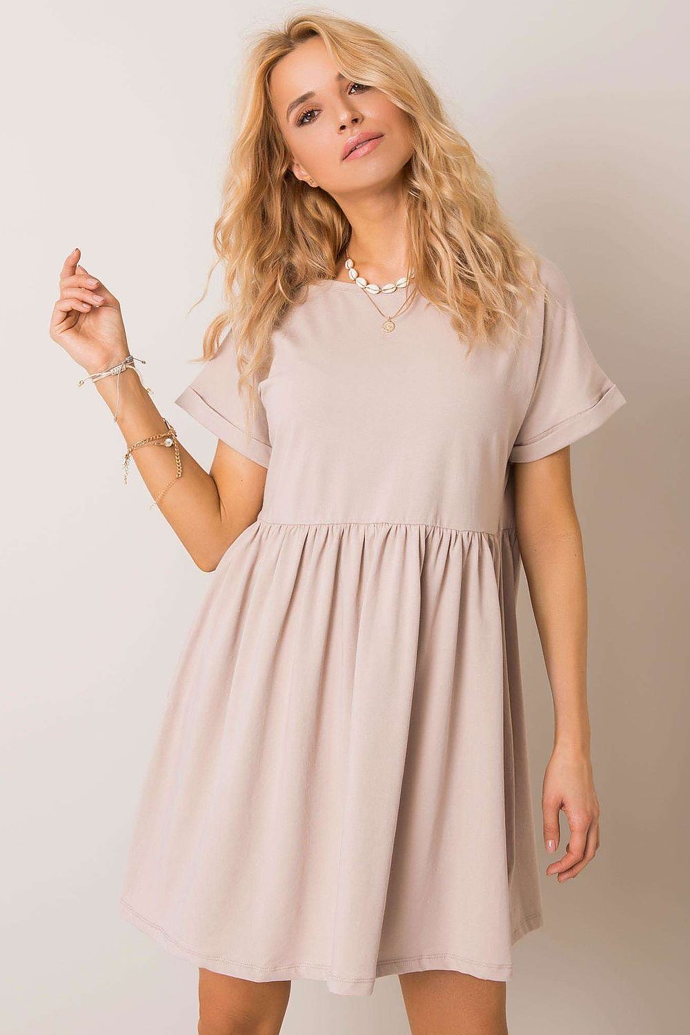 Sublime woman wearing a beige flared cotton dress by Rue Paris, embodying sophistication with short sleeves for versatile daytime allure.