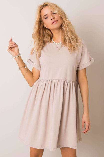 Sublime woman wearing a beige flared cotton dress by Rue Paris, embodying sophistication with short sleeves for versatile daytime allure.