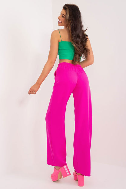 Back view of a model wearing stylish pink high waist trousers with a green crop top, highlighting the elegance and comfort of women's fashion by Rue Paris.