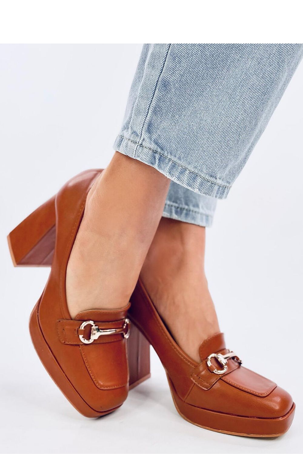 Chic Inello women's brown platform pumps elegantly styled with denim, highlighting the 10.5cm heel and distinct buckle design for a fashionable look.