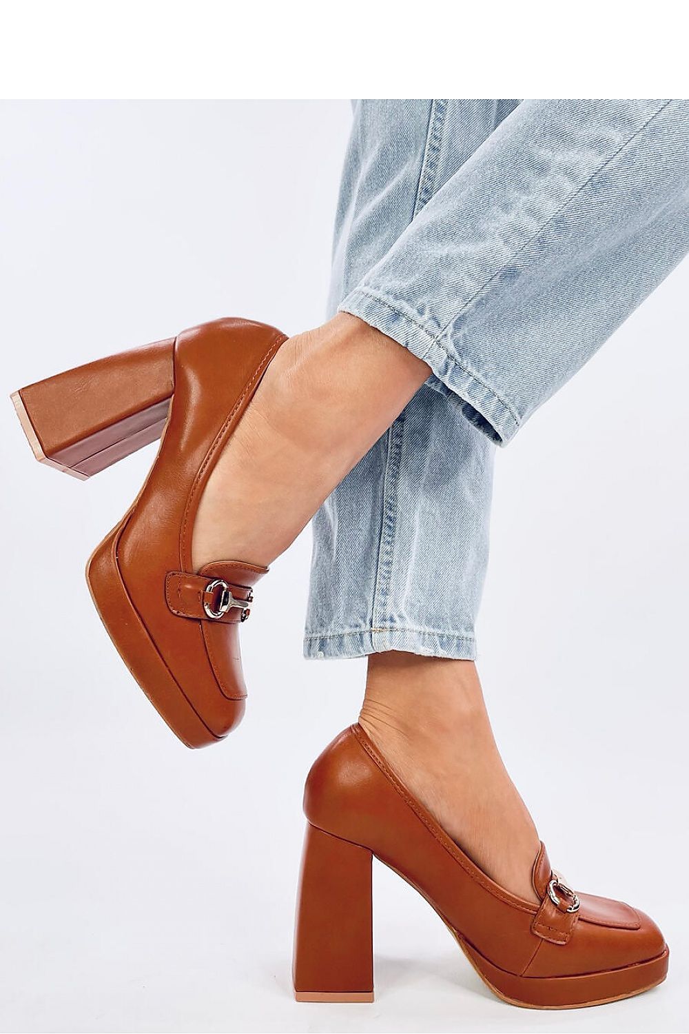 Sophisticated image of Inello women's platform pumps in brown, designed with a striking buckle and 10.5cm heel, perfectly paired with casual denim for a trendy outfit.