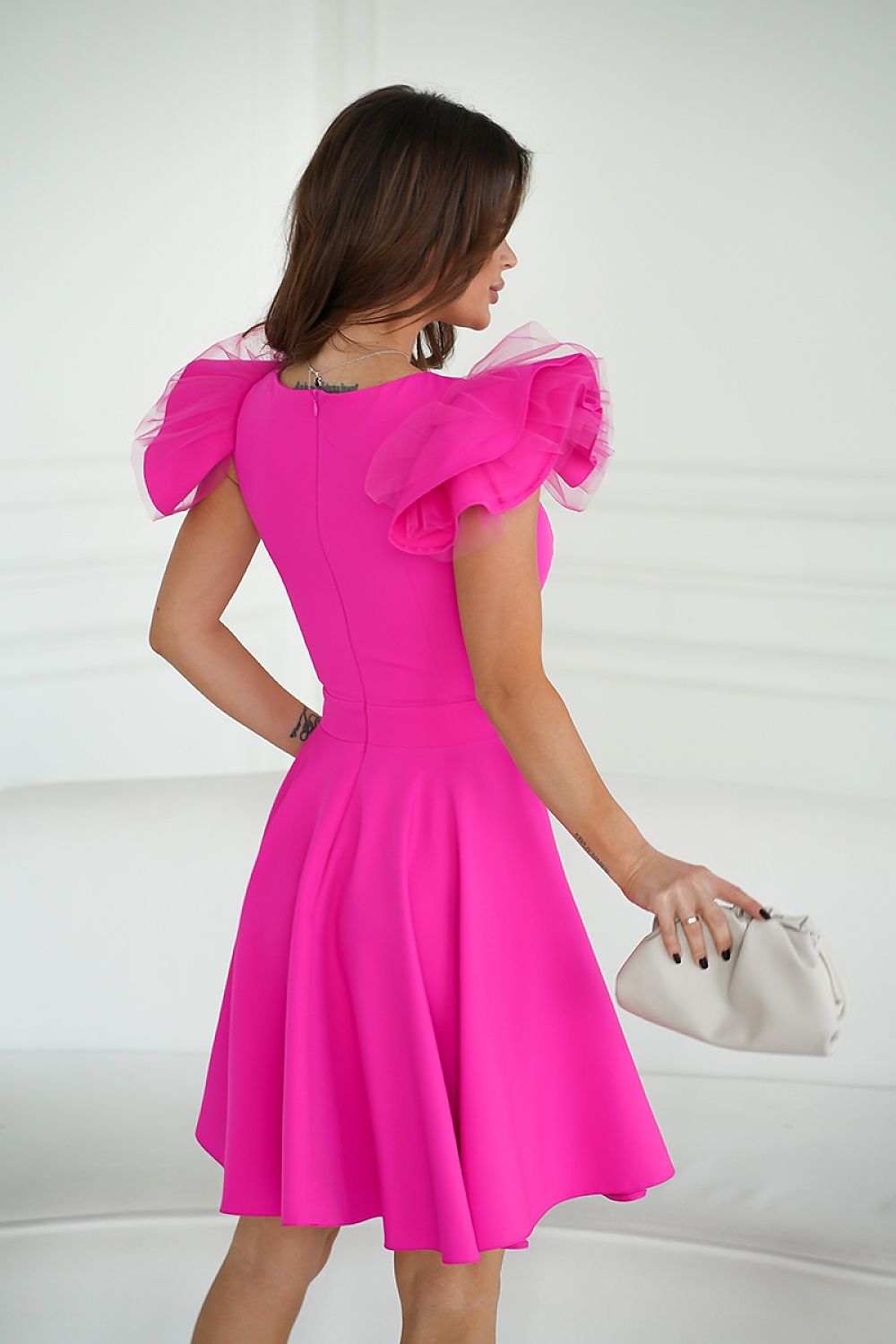 Back view of the Bicotone pink cocktail dress highlighting the unique shoulder design and flattering fit, suitable for stylish parties.