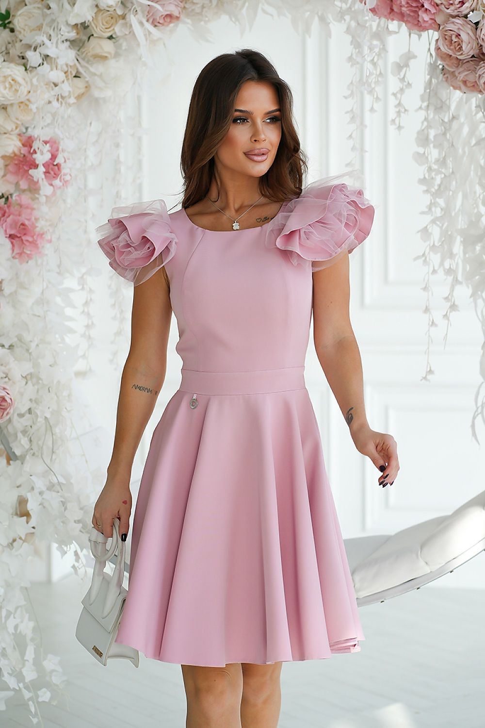 Charming pink cocktail dress by Bicotone with distinctive shoulder ruffles, elegantly cut to enhance the waistline, perfect for special occasions.