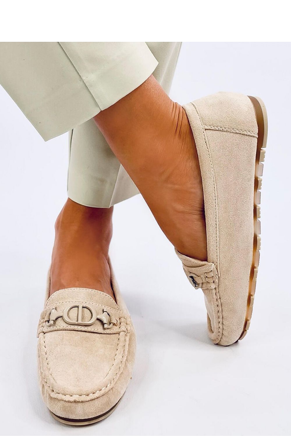 Elegant women's suede moccasins featuring a unique silver buckle and cushion insole, showcased on a beautifully groomed foot, courtesy of Inello.