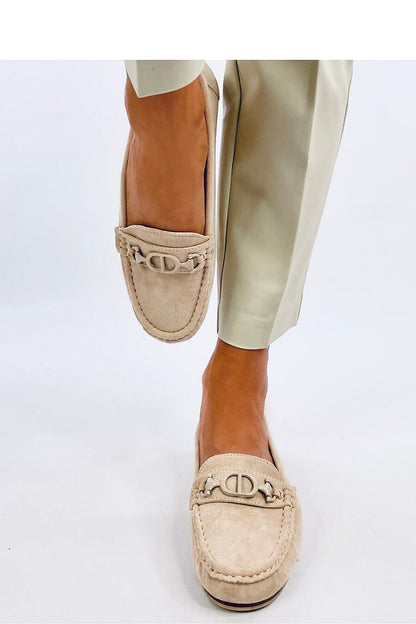 Chic women's suede moccasins with signature buckle detail, displayed in a stylish stance, representing luxury comfort from Inello.