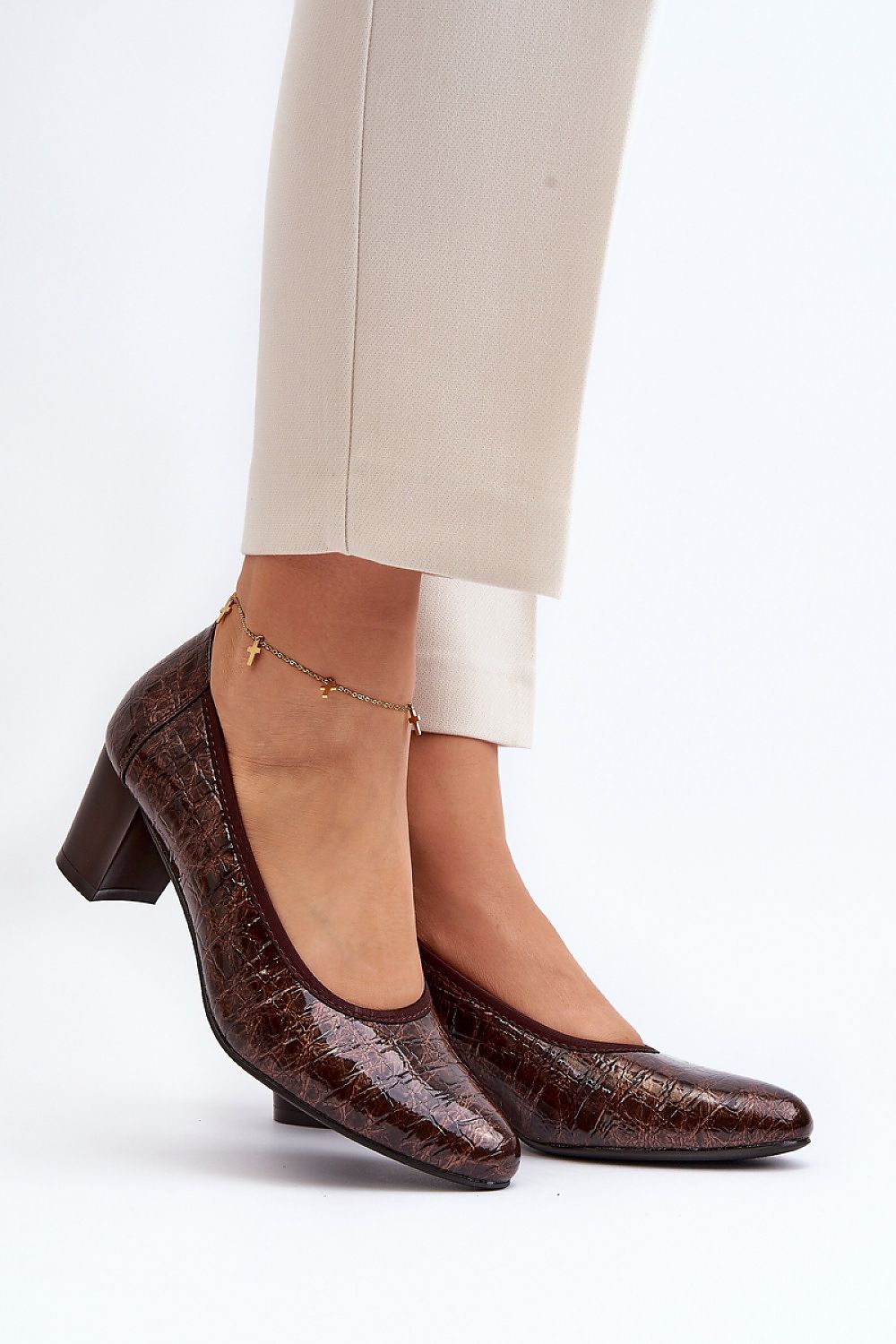 Elegant block heel pumps in rich brown with a glossy finish, featuring an almond toe design and natural leather insole. Worn elegantly by a model, showcasing the perfect blend of comfort and style from Step in Style.
