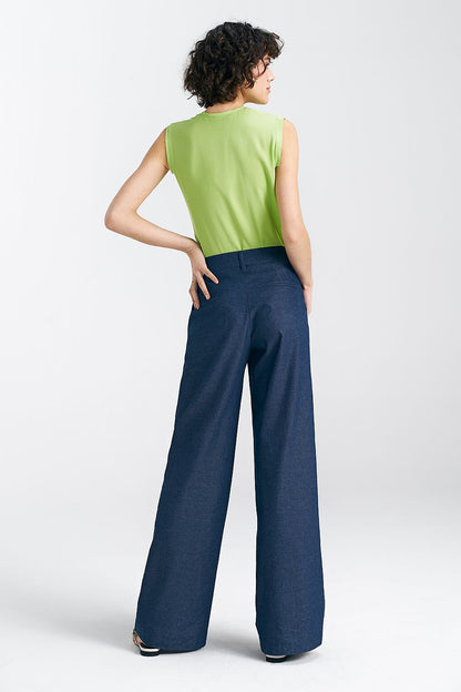 Back view of sophisticated Nife women's wide leg trousers, showcasing their tailored fit and stylish back detailing, completed with a fresh green blouse.
