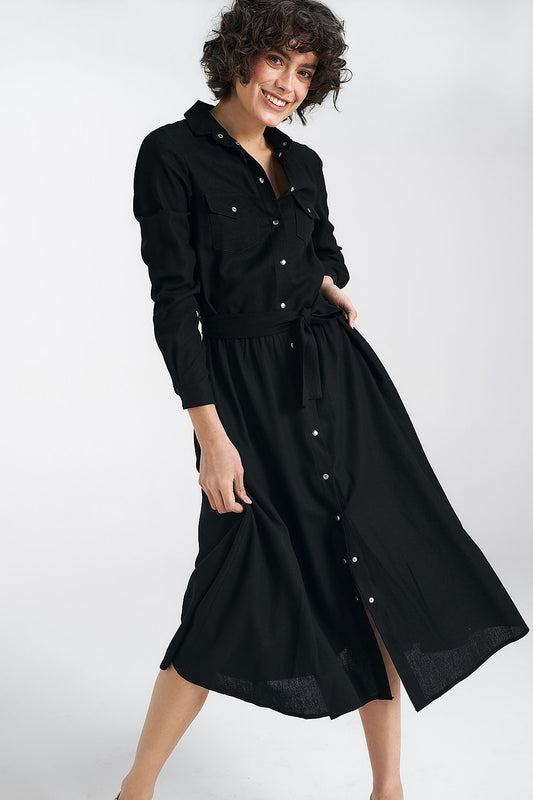 Elegant black midi daydress by Nife featuring a classic collar, cuffed sleeves, and stylish pockets, model wearing the dress.