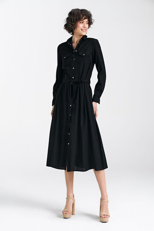 Chic black midi daydress by Nife with a belted waist, model showcasing the sophisticated design and classic collar.