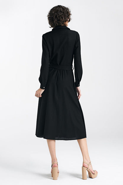 Back view of a luxurious black midi daydress by Nife, highlighting the elegant cut and cuffed sleeves worn by the model.