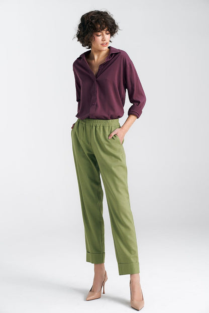 Chic front view of an oversized long sleeve viscose shirt in deep plum by Nife, elegantly paired with luxe green trousers for a modern and classy outfit.