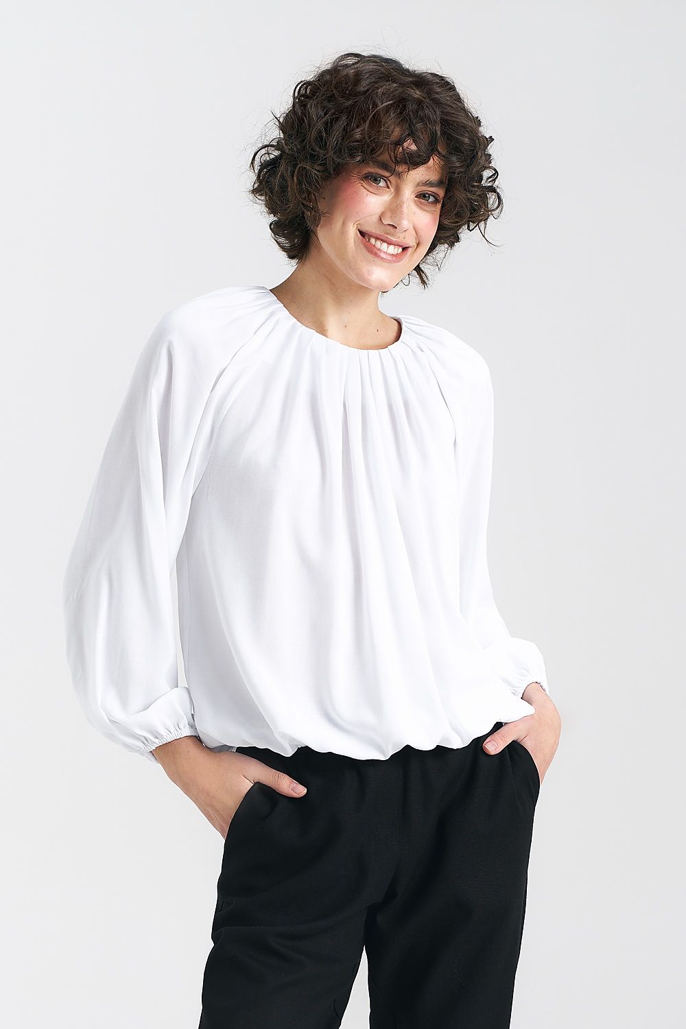 Nife white viscose blouse featuring a pleated neckline, styled casually with black trousers, ideal for a chic summer outfit.