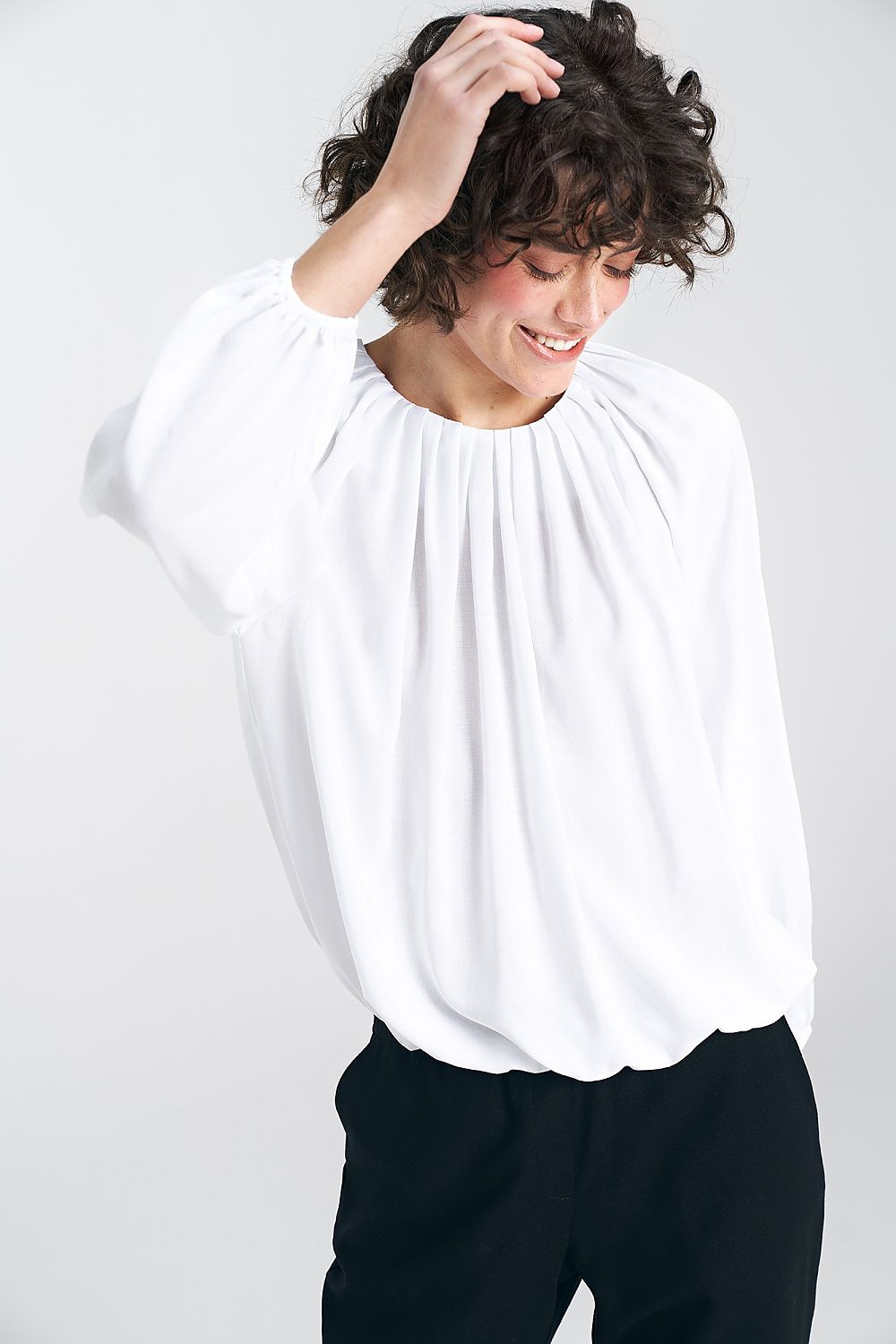 Stylish white blouse by Nife, highlighting its sophisticated pleated neckline and relaxed silhouette, perfect for casual summer outings.