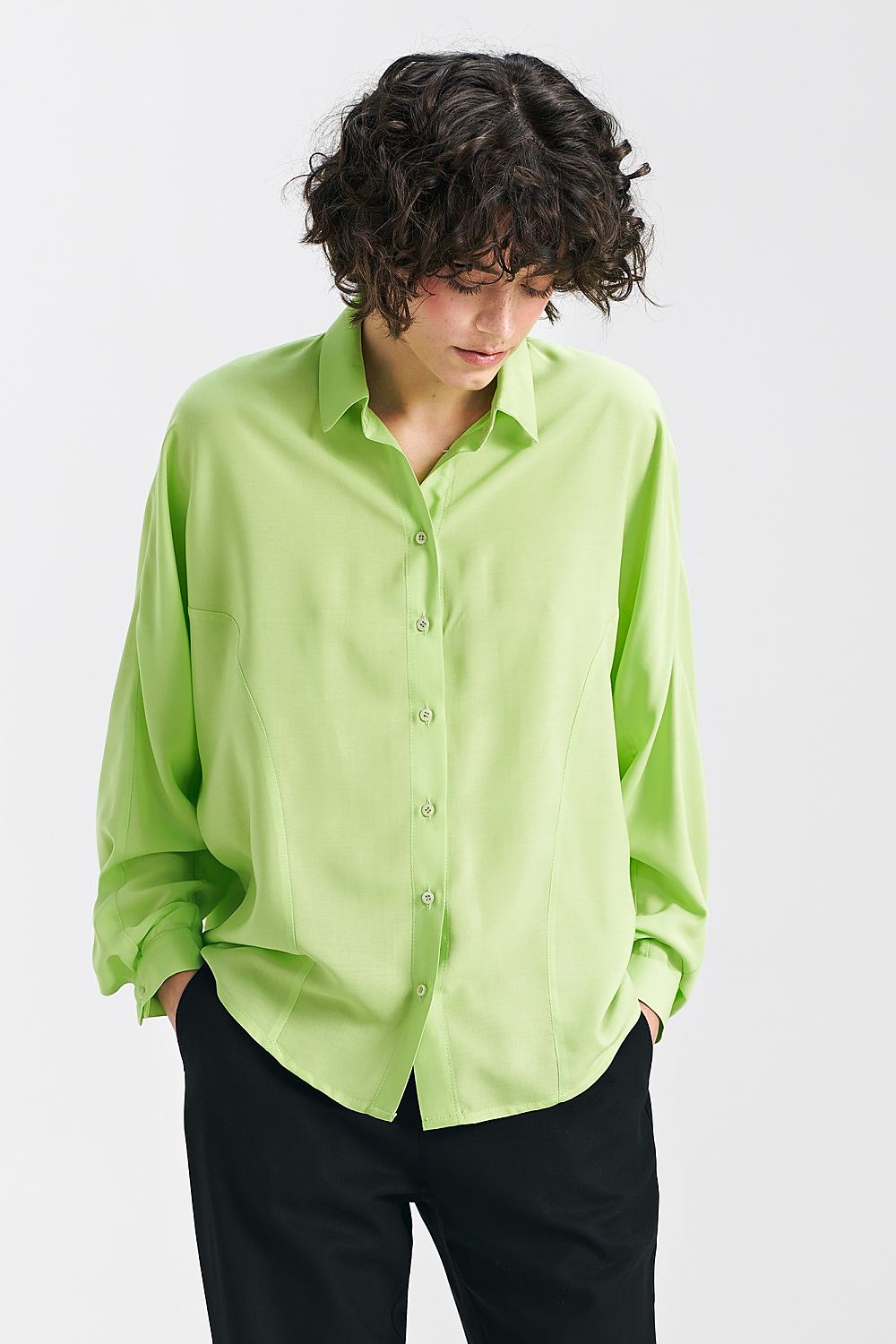 Lime oversize long sleeve shirt with classic collar and bat sleeves by Nife, elegantly worn by a model with curly hair, showcasing its relaxed fit.