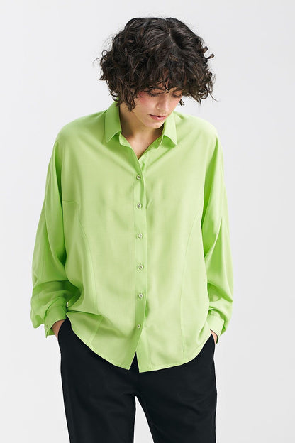 Lime oversize long sleeve shirt with classic collar and bat sleeves by Nife, elegantly worn by a model with curly hair, showcasing its relaxed fit.