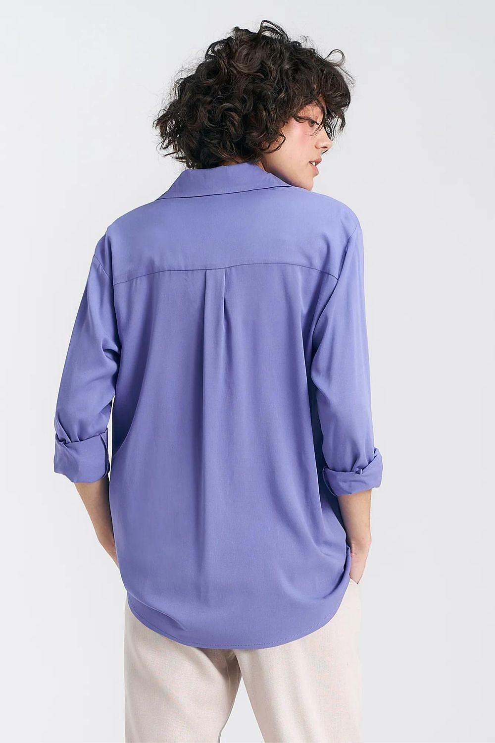 Back view of an elegant oversized long sleeve viscose shirt in lavender by Nife, highlighting the yoke detail and flowy fit, paired with cream trousers for an upscale look.