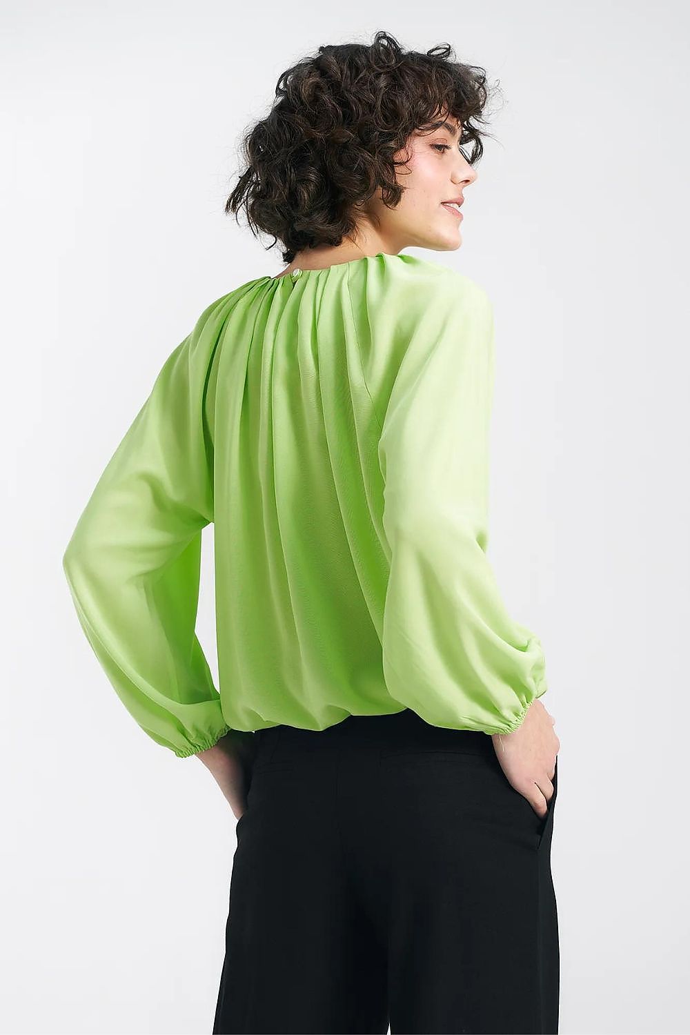 Back view of the Nife lime viscose blouse, highlighting the ruffled hem and pleated detail, embodying summer elegance.