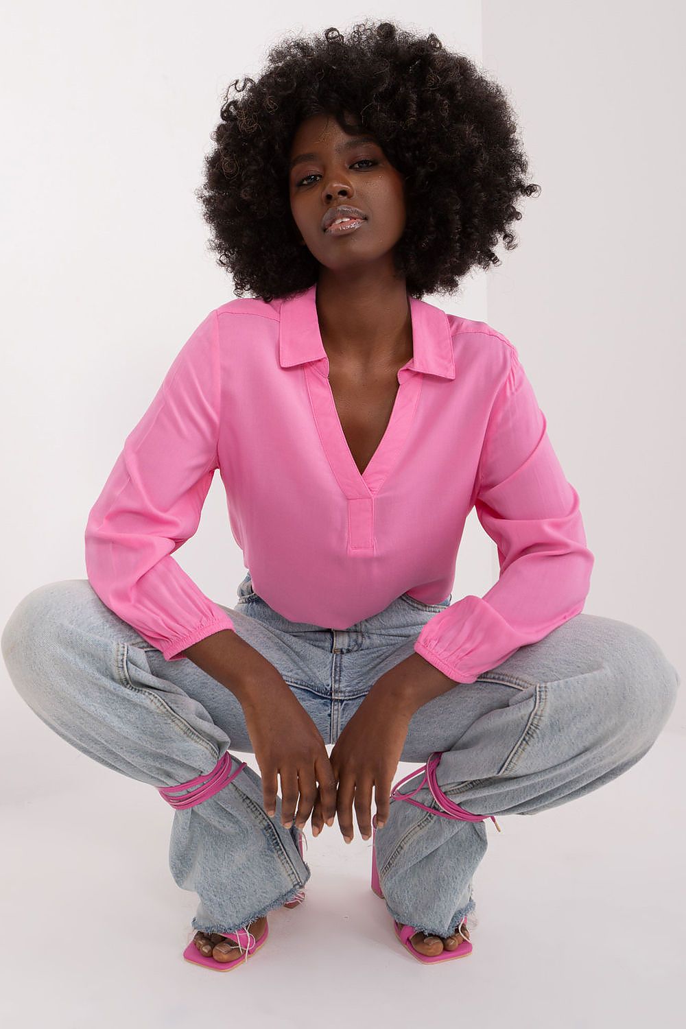 Fashionable pink everyday blouse by Sublevel, showcasing a heart neckline and relaxed fit, paired with stylish baggy jeans for a contemporary, luxurious vibe.