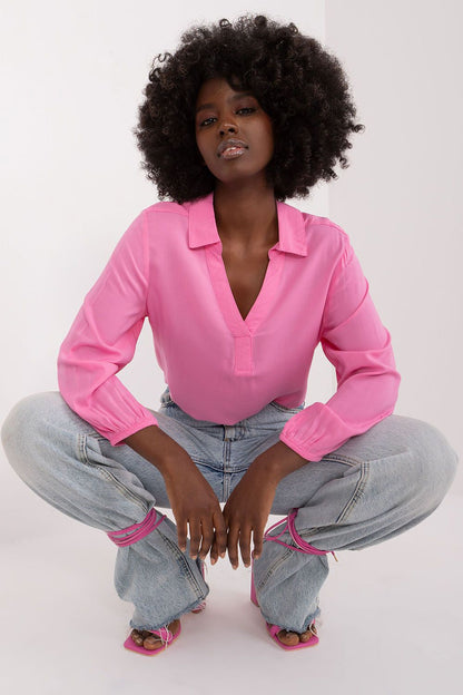 Fashionable pink everyday blouse by Sublevel, showcasing a heart neckline and relaxed fit, paired with stylish baggy jeans for a contemporary, luxurious vibe.