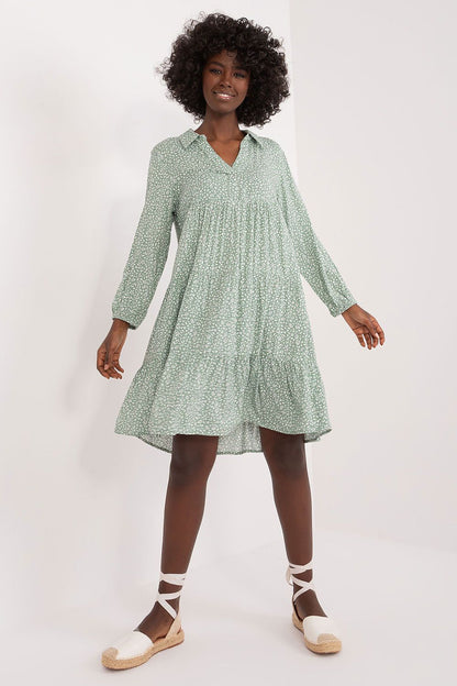 Elegant model showcasing an oversized summer dress by Sublevel in lightweight viscose. The dress features a unique green print with a ruffle hem, ideal for casual and stylish summer outings.