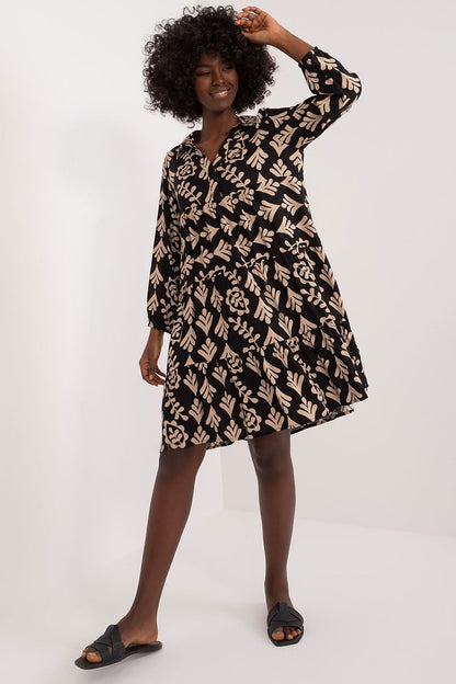 Graceful model presenting a luxurious oversized summer dress by Sublevel in a bold black fabric with an intricate print. Perfectly designed for effortless summer sophistication.