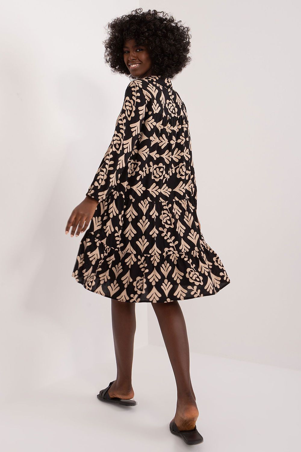 Back view of a model adorned in an oversized summer dress by Sublevel, highlighting its beautiful floral pattern and lightweight design for a chic summer style.