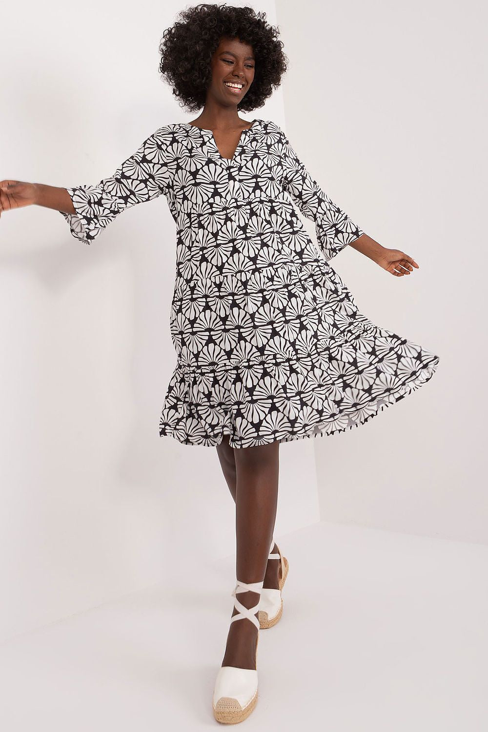 Model gracefully twirling in an elegant summer viscose daydress by Sublevel, highlighting the 3/4 sleeves and ruffle hem, perfect for a sophisticated summer look.