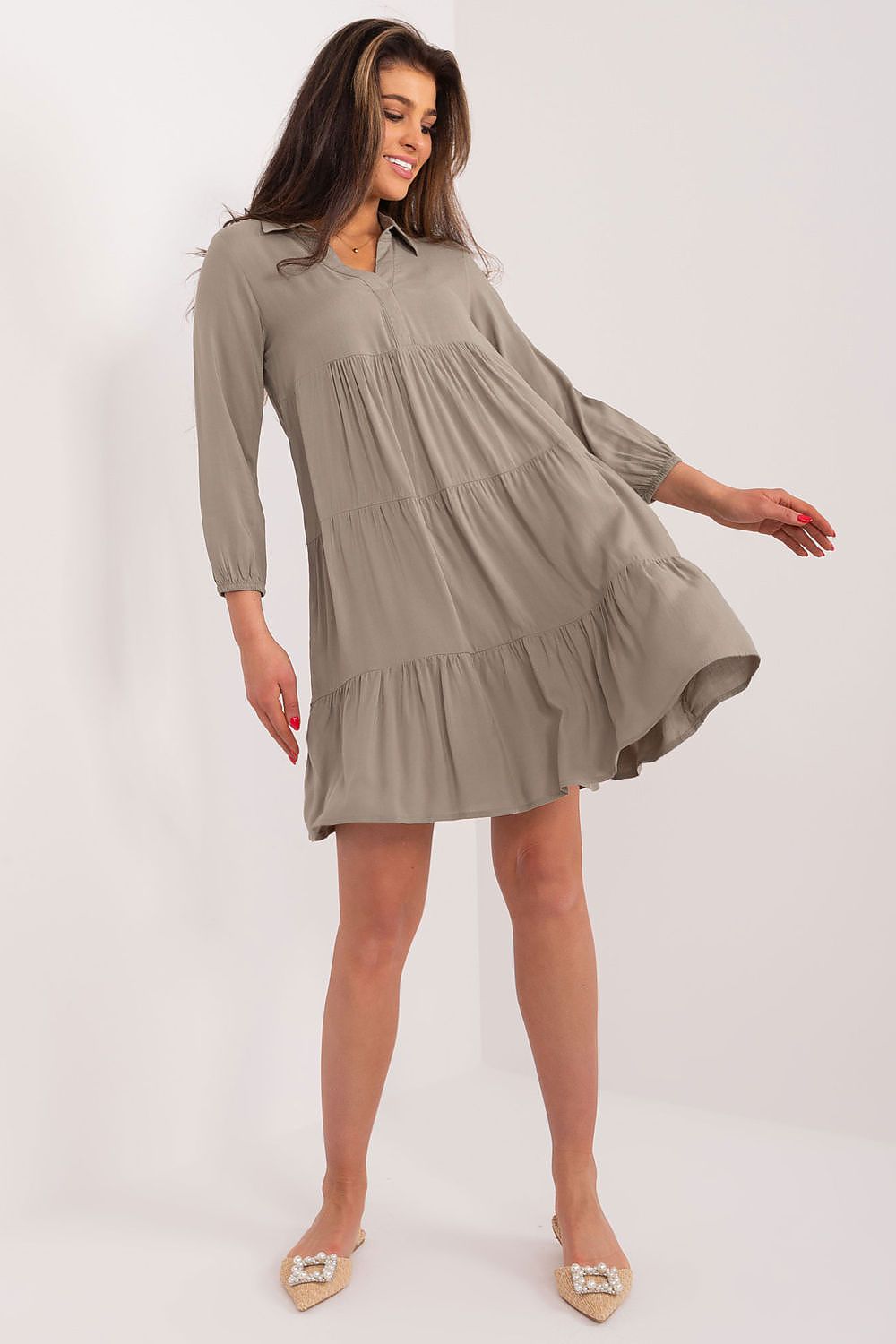 Charming model showcasing a khaki oversized summer dress by Sublevel, crafted from soft viscose with a relaxed fit and ruffle details, ideal for sophisticated summer outings.