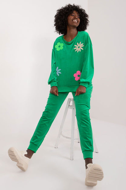 Chic green velour sweatshirt and matching high waisted pants decorated with vibrant flowers, styled on a model, by Italy Moda.