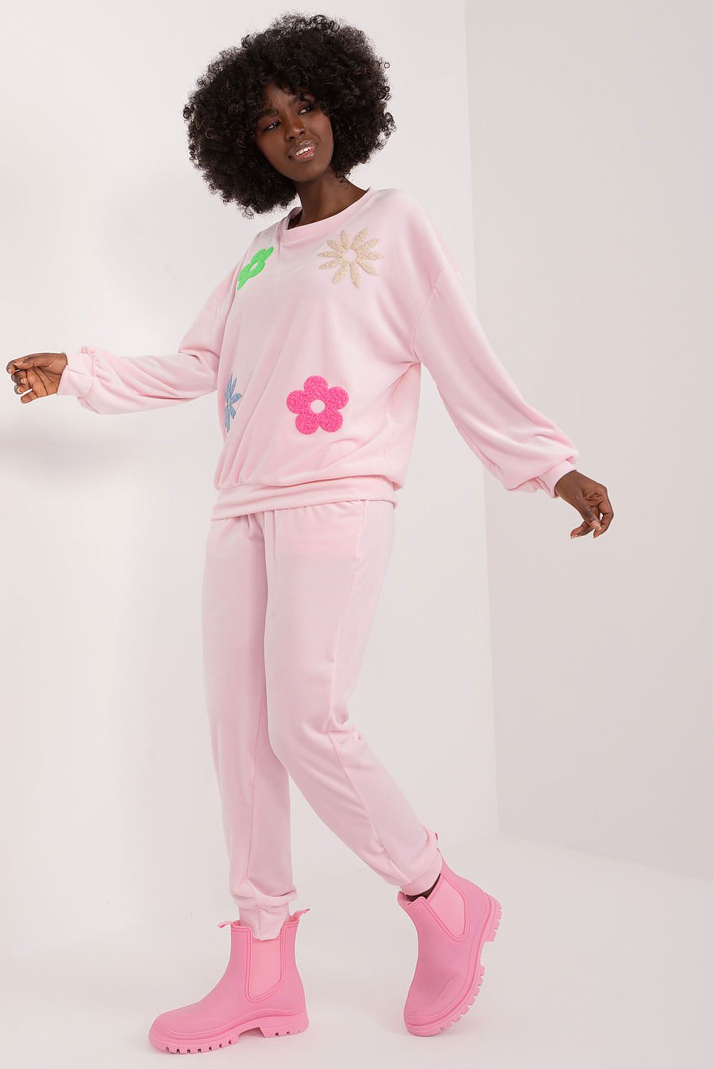 Sophisticated pink velour set with decorative floral accents on the sweatshirt and pants, captured on a model, by Italy Moda.