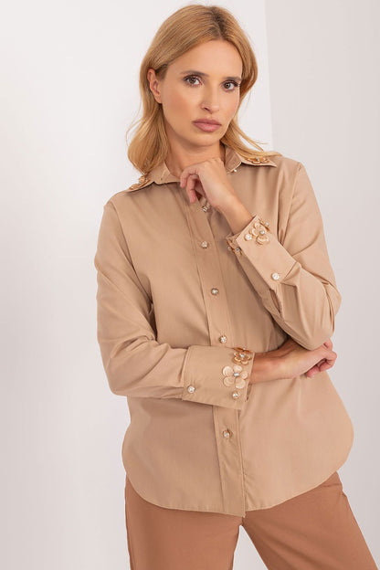 Luxurious Lakerta long sleeve cotton shirt in beige, highlighting refined details such as embroidered flowers and decorative zircons, with the model confidently presenting a chic pose.