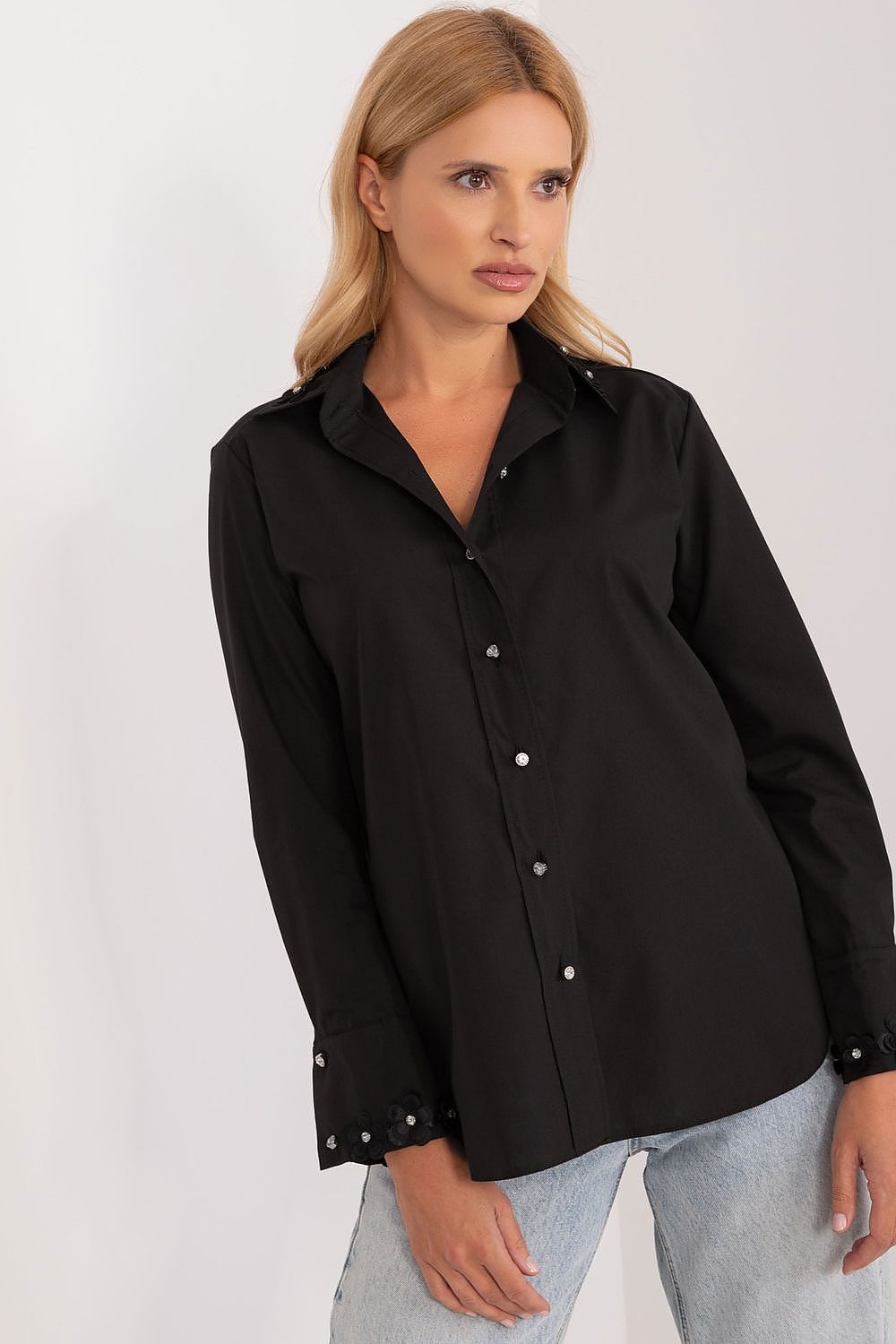 Chic black long sleeve shirt by Lakerta, featuring exquisite embroidered details and zircons on the cuffs, elegantly styled by the model, illustrating a modern luxury aesthetic.