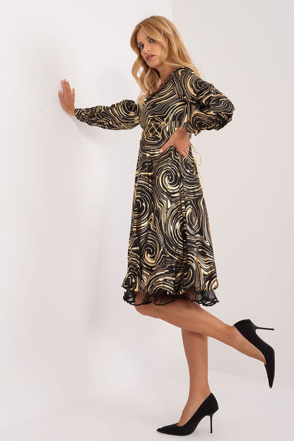 Sophisticated Lakerta evening dress with an elegant flared cut and long buff sleeves, highlighted by a luxurious gold and black swirl pattern.