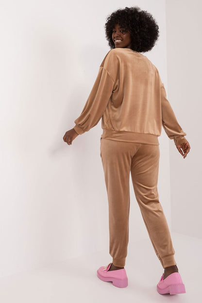 Back view of a woman in an elegant floral print velour set by Italy Moda, showcasing the comfortable and stylish sweatshirt and high waisted pants.