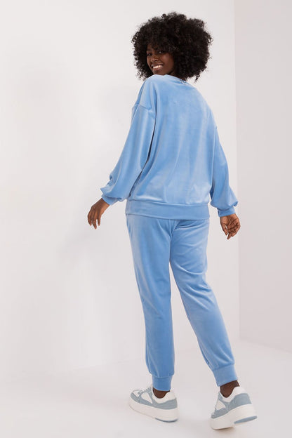 Model positioned in a relaxed pose wearing a blue elegant floral print velour set by Italy Moda, combining sophistication and everyday comfort.