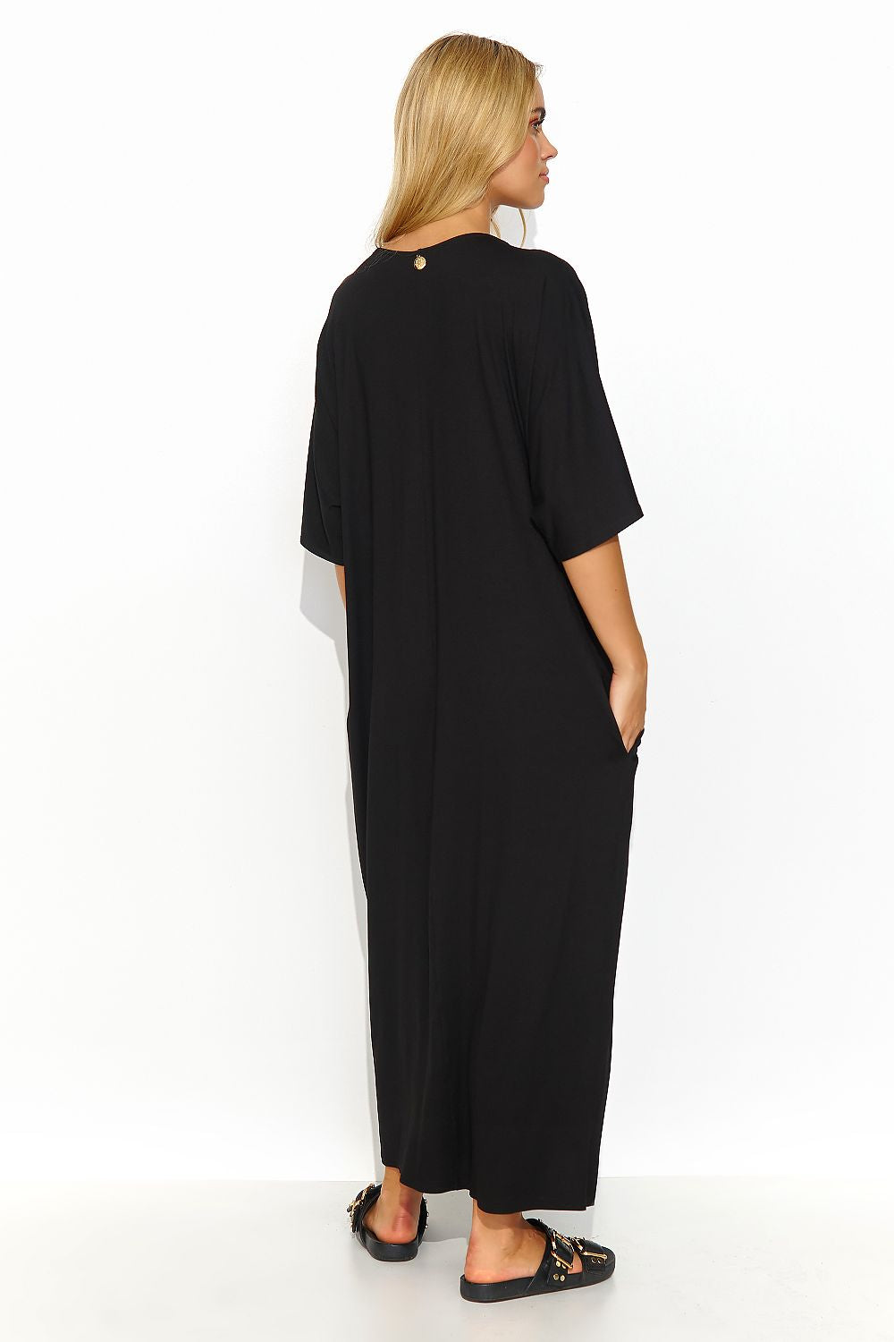 Elegant back view of a black Makadamia long dress with short sleeves and a chic design, featuring practical pockets for a touch of luxury.