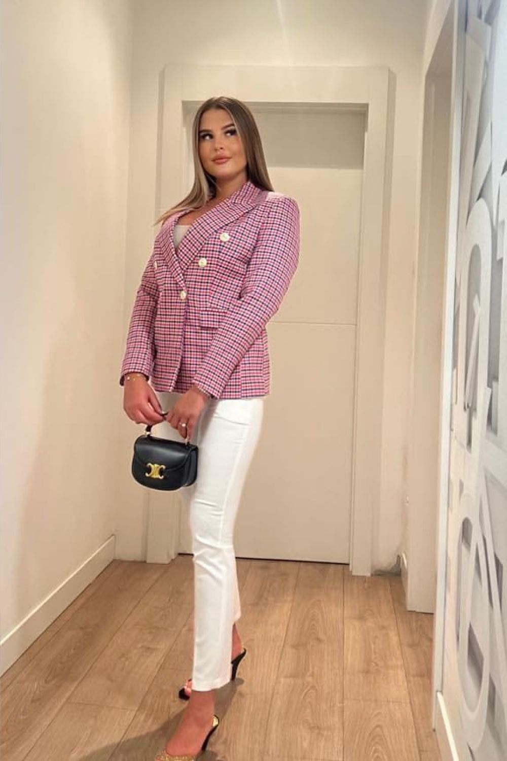 Luxury women’s blazer jacket by Cabba in a vibrant pink check pattern, complemented by white fitted trousers, showcasing an elegant and sophisticated outfit.