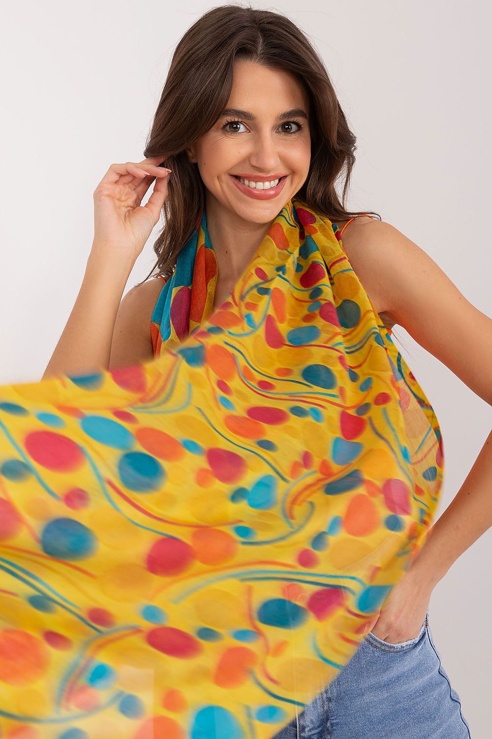 Elegant model showcasing a vibrant luxury neckerchief by AT, featuring a unique print with colourful patterns, made from 100% cotton. The neckerchief has dimensions of 184 cm in length and 70 cm in width.
