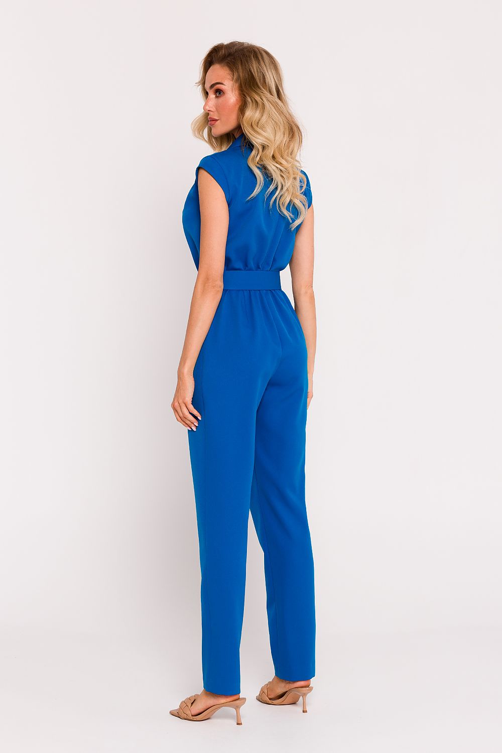 Elegant Polish tailored jumpsuit by Moe featuring a sophisticated asymmetrical design and a stylish belted waist.