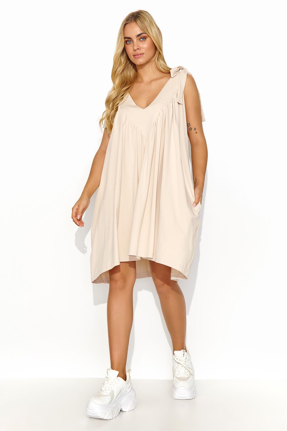 Close-up of the intricate gold accent on the back of a luxurious Makadamia summer maxi dress, highlighting its elegance and glamour.