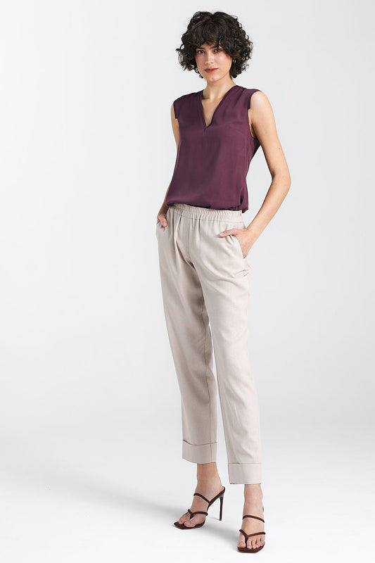 Stylish sleeveless plum blouse by Nife, made from 100% viscose, showcasing a chic V-neckline and refined pleat embellishments.