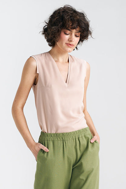 Side angle of a plum viscose blouse by Nife, highlighting the stylish pleat detail and elegant silhouette perfect for warm weather.
